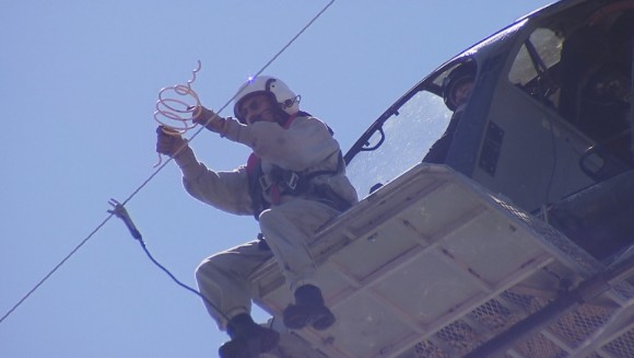 A flight crew from Haverfield Aviation attaches a bird repellent called a firefly to power lines beside the Lesner Bridge in Virginia Beach. Credit: Walter Hildebrand/WAVY TV